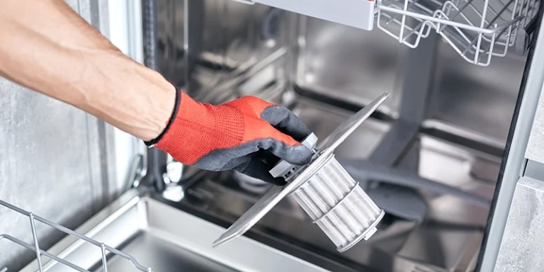 dishwasher - Simple Care for Your Dishwasher - person holding filter removed from dishwasher
