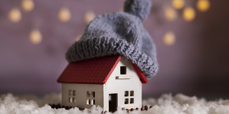 winterizing home - 5 Easy Tips for Winterizing the Outside of Your Home - toy house with wool cap on roof