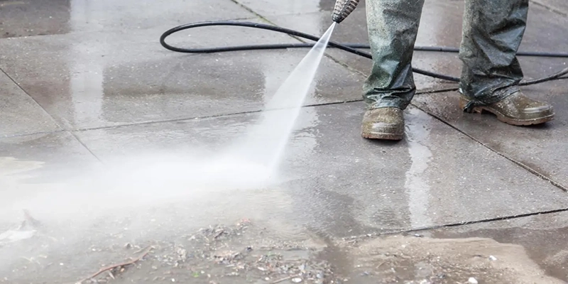 Reduced Water Pressure in Your Home - person with high pressure sprayer cleaning floor