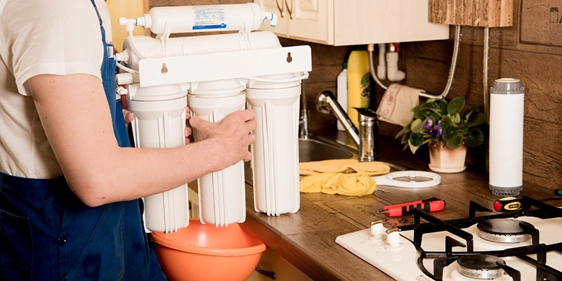 water filtration - Water Filter vs. Water Softener Identifying - person holding water filtration system filters