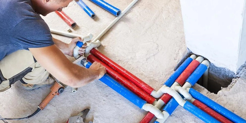 repiping - How Much Does House Repiping Cost - plumber adjusting a system of pipes