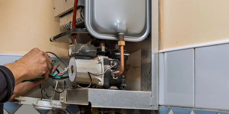 water heaters - Replacing your hot water heater - plumber adjusting wiring inside a water heater